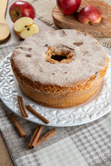 Sponge cake or chiffon cake with apples so soft and delicious sliced ​​with ingredients: cinnamon, eggs, flour, apples on wooden table. Home bakery concept for background and wallpaper
