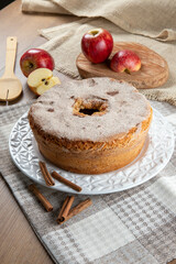 Sponge cake or chiffon cake with apples so soft and delicious sliced ​​with ingredients: cinnamon, eggs, flour, apples on wooden table. Home bakery concept for background and wallpaper