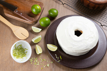 Moist lemon fruit cake on plate with lemon slices on wooden table. Delicious breakfast, traditional tea time. Lemon cake recipe. Top view.