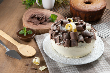 White chocolate and dark chocolate cake two loves on wooden table. Birthday and wedding cake