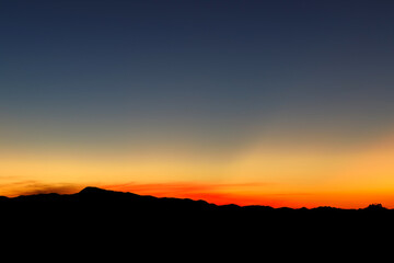Heaven at early morning with copy space. Sunset, sunrise backdrop.Predawn clear sky with orange horizon and blue atmosphere. Smooth orange blue gradient of dawn sky.