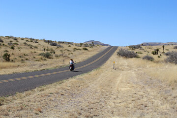 Fototapeta na wymiar Woman riding on a motorcycle on the Davis Mountains Scenic Loop in West Texas alone