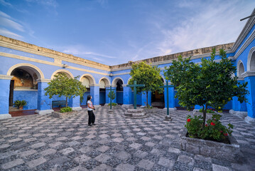 Turista latina apreciando el claustro de los naranjos del monasterio Santa Catalina en Arequipa