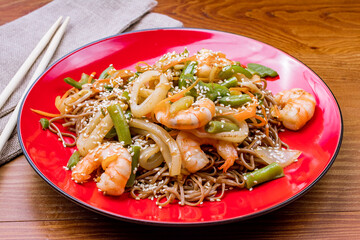 Fried soba noodles with seafood on wooden table