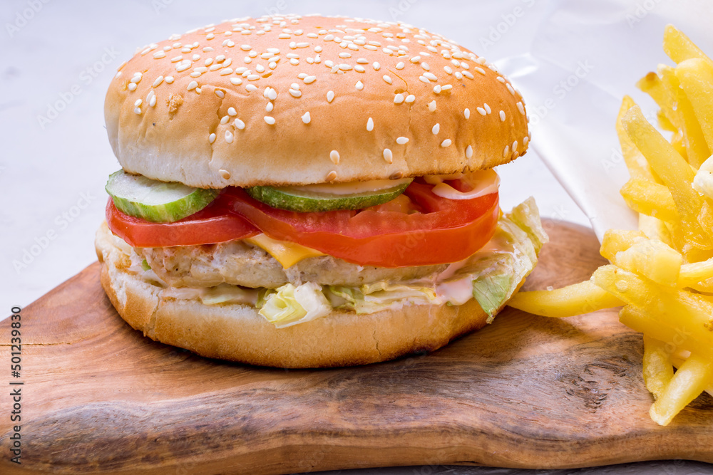 Sticker burger with chicken, vegetables and french fried on the board macro close up