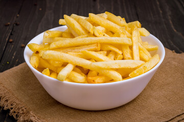 french fries on bowl on black wooden table