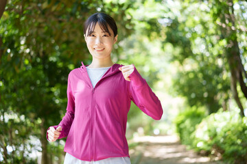 公園でジョギングをする女性