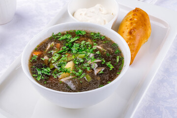 mushroom soup with sour cream on the bowl on a white table macro close up