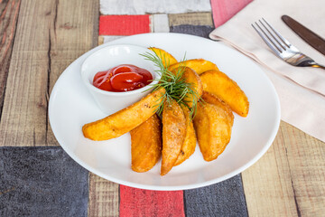 The potatoes wedges on a white plate with ketchup