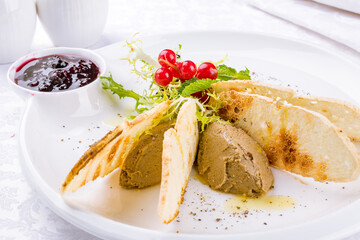 The chicken liver pate with bread and jam on a white plate macro close up