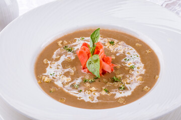 cream of porcini mushroom soup on a white plate macro close up