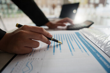 Close up Businessman hand holding pen and pointing at financial paperwork with social network diagram..