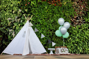 Cozy kids room interior with play tent, balloons and tropical green leaves background.