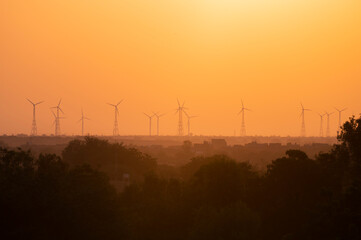 Sun rising on Thar desert, Jaisalmer, Rajasthan, India. Windmills in distant horizon.