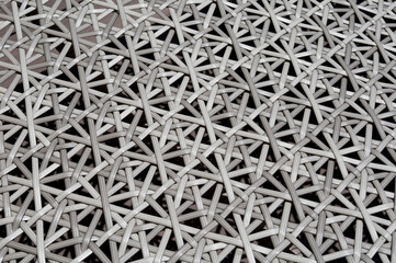 Close up of the pattern formed by open weave rattan cane on a chair seat