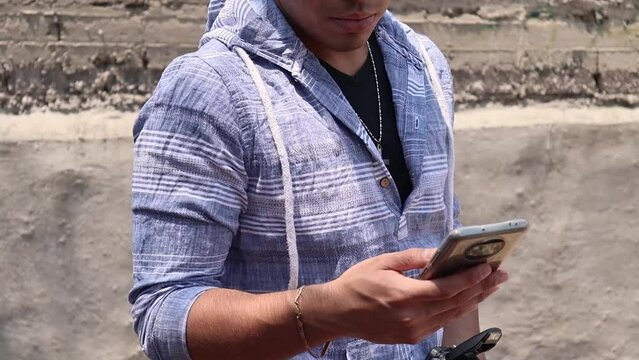 Joven mandando mensajes por tel&eacute;fono