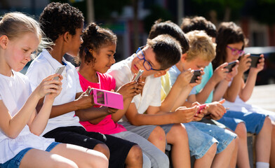 Children are playing on smartphone in the playground. High quality photo