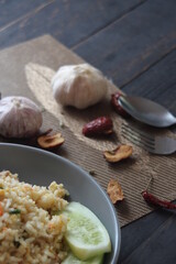 Pork fried rice is a common street food in Thailand. Served on a black wooden table.