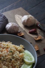 Pork fried rice is a common street food in Thailand. Served on a black wooden table.