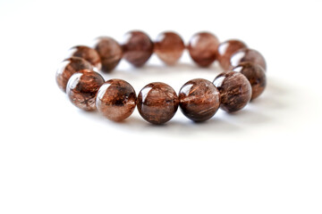 Mica rutilated quartz bracelet on white background.  Brown crystal bracelet gemstones.  Copy space...