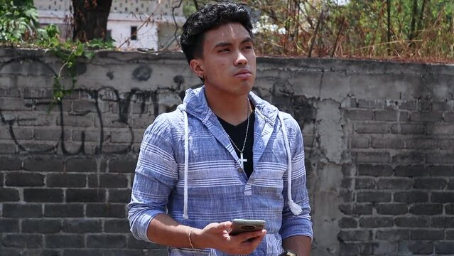 Joven mandando mensajes en su tel&eacute;fono