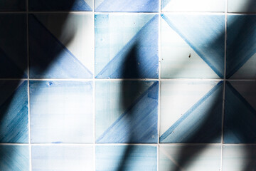 Wall tiles texture in blue and white color. Interference of light and shadows
