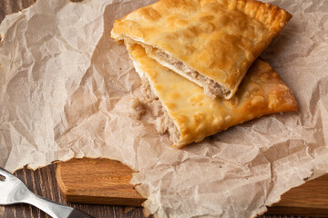 Uzbek eastern Tatar cuisine, cheburek on a wooden board. Cheburek - fried pie with meat. Traditional dish of Turkish and mongolian,pasties empanada.