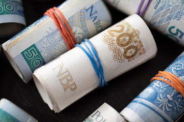 Close-up view of multiple banknotes rolled up. Various denominations of the Polish national currency.