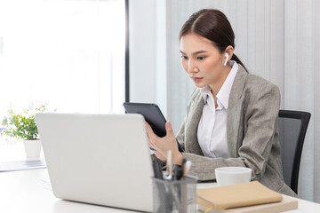 Business woman using a tablet to work in the office.., World of technology and internet communication, Using tablet to conduct financial transactions because the convenience and speed...