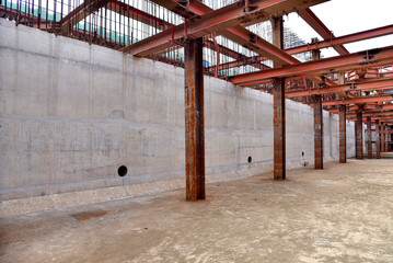 Reinforced steel frame structure under the construction building with steel piles screwed into the ground. Industrial concept.