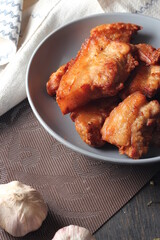 Fried Pork Belly with Fish Sauce Served on a Gray plate on a black wooden floor.