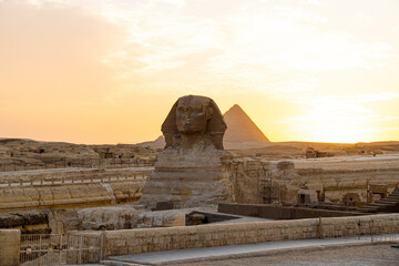 Archaeological complex of Great Egyptian Pyramids is located on the Giza plateau. second pyramid of Chephren khefren in the night light at sunset. sun sets behind the pyramid. sphinx at sunset