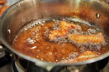 Bugnes, French donuts in boiling oil in saucepan