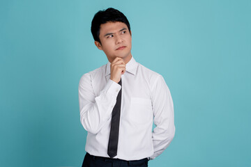 Portrait of minded interested boy touch hand chin look copyspace, think thoughts ask question answer, isolated over blue color background