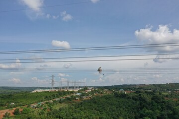 Electricians does a maintenance and installation on high voltage  power transmission lines to provide electricity for production. Industrial concept.