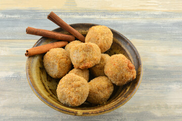 Apple cinnamon oatmeal balls with cinnamon sticks in bowl on table