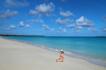 Pregnant woman sitting at Fayaoue beach on the coast of Ouvea lagoon, Mouli and Ouvea Islands, New Caledonia