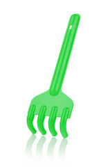 Green plastic rake isolated on a white background, with reflection, close-up. Children's toys for playing in the sandbox. Games for early child development