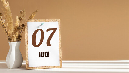 july 7. 7th day of month, calendar date.White vase with dead wood next to cork board with numbers. White-beige background with striped shadow. Concept of day of year, time planner, summer month