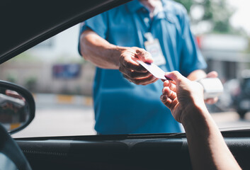 Young Asian . man driving car hand holding credit card payment for gasoline at petrol station....