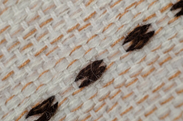A defocused shot of the fabric.  White, brown and black threads. Abstract multitasking background. Macro shot. Selective focus. Blur, noise, grain effect