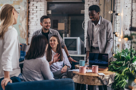 Team of employees having casual discussion at cafe.
