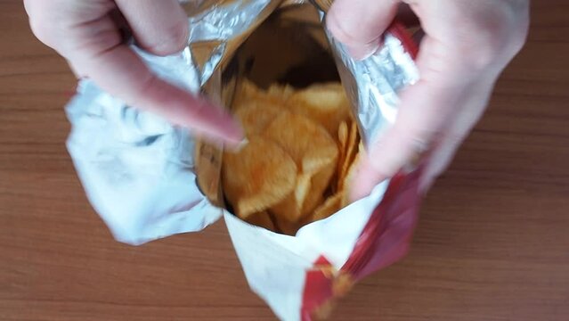 Potato chips with spices open the package. Close up of fast food.