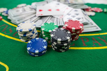 multi-colored poker cards, chips, dollar bills, on a new green poker table. Poker concept.