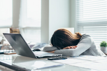 Female student puts her head on the table and sleeps