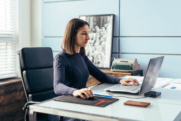 Woman with laptop at desk working remotely or learning online.