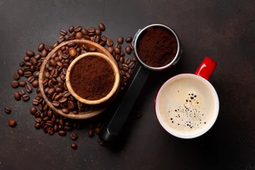 Fotobehang Roasted coffee beans and ground coffee in filter holder © karandaev