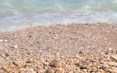 seashore, small pebbles.the texture of the coast.beautiful beach recreation ,Women's ankles in the sand. Rest on the sand of the beautiful turquoise sea on a sunny hot summer day. Hello summer.