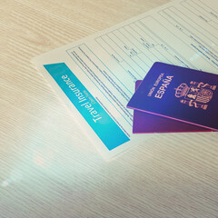 Closeup of travel insurance and hispanic passports on wooden table