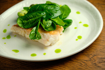 Pike perch fish fillet with spinach leaves
